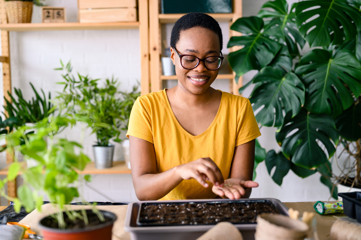 Young smiling woman doing seed-starting early in the spring indoors