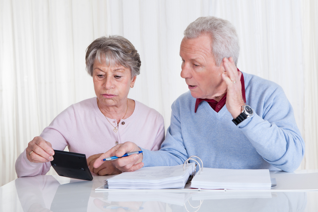 Elderly couple stressed out paying bills on limited budget
